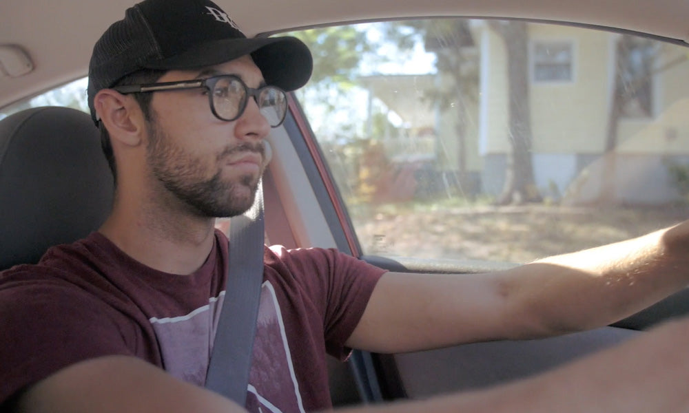 Driver operating vehicle with Vue smart navigation glasses listening to route guidance